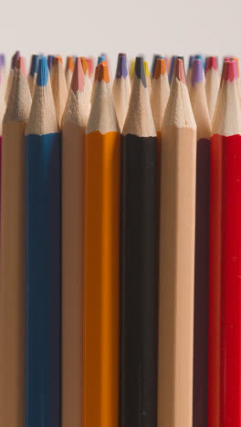 Vertical-Video-Studio-Shot-Of-Rotating-Multi-Coloured-Pencils-Against-White-Background